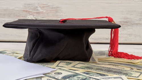 graduation cap sitting on money