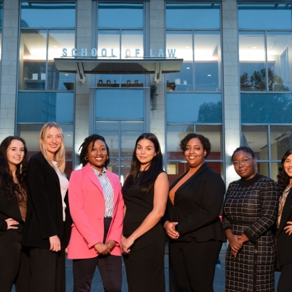 Law school students pose in front of School of Law building.