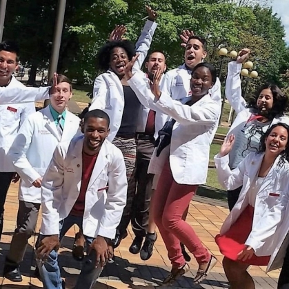 ODASIS students wearing white coats jumping.