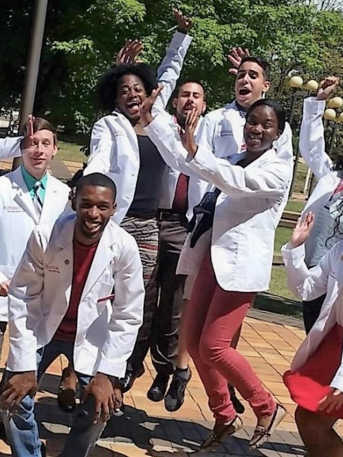 ODASIS students wearing white coats jumping.