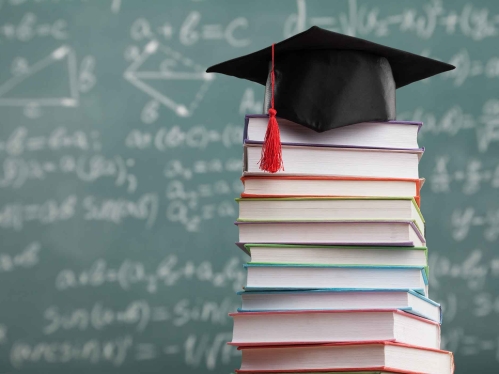 Photo of books, graduation cap, and chalkboard