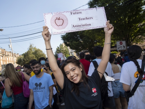 Student raises Future Teachers Association sign over her head during Rutgers involvement fair.